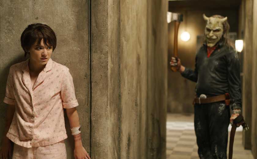 The Grabber (Ethan Hawke) holding an axe while stalking Gwen (Madeleine McGraw) in Black Phone 2